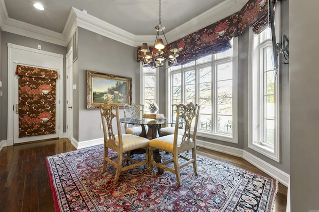 dining space with dark hardwood / wood-style flooring, ornamental molding, and a chandelier