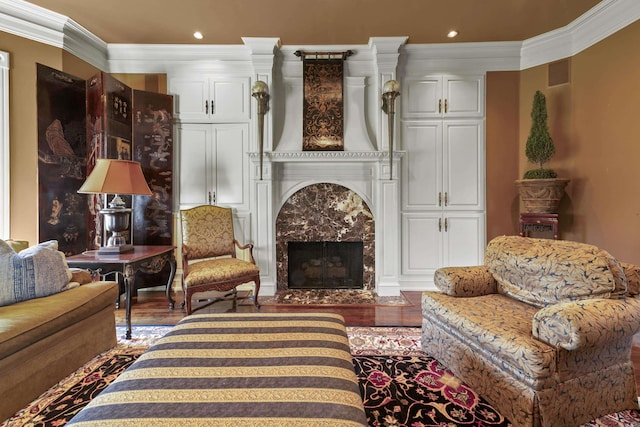 living room featuring a premium fireplace, wood-type flooring, and ornamental molding