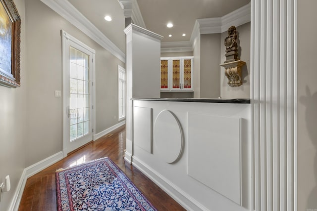 doorway to outside featuring hardwood / wood-style floors, ornate columns, and crown molding