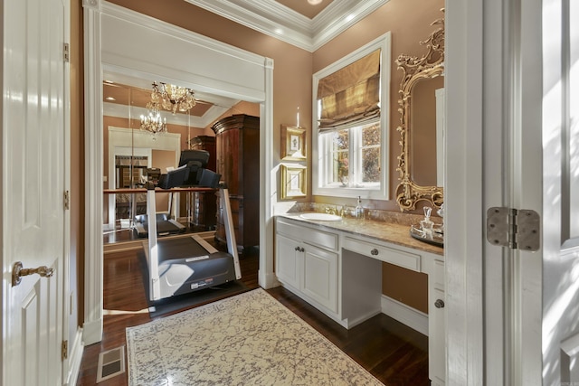 bathroom with vanity, ornamental molding, a notable chandelier, and hardwood / wood-style flooring