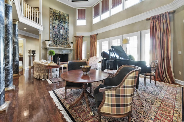 dining room with hardwood / wood-style flooring, a towering ceiling, and crown molding