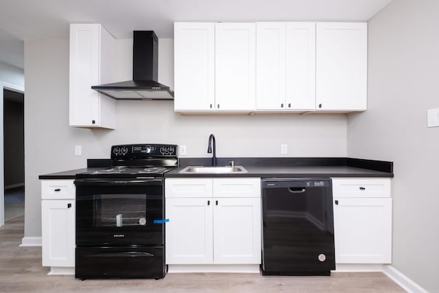 kitchen with white cabinetry, black appliances, and wall chimney range hood