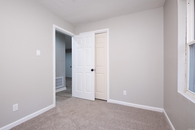 unfurnished bedroom featuring light colored carpet and a closet