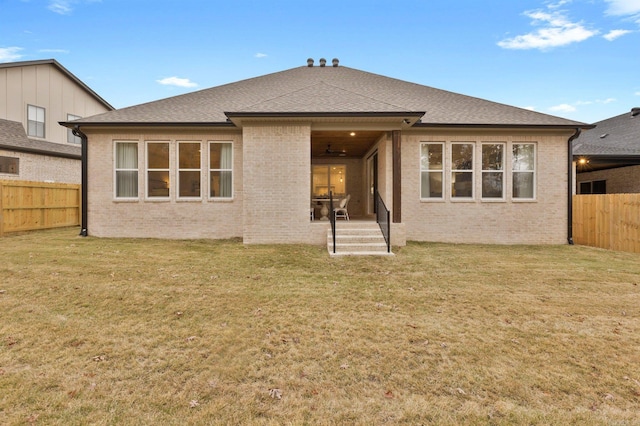 rear view of house featuring a lawn