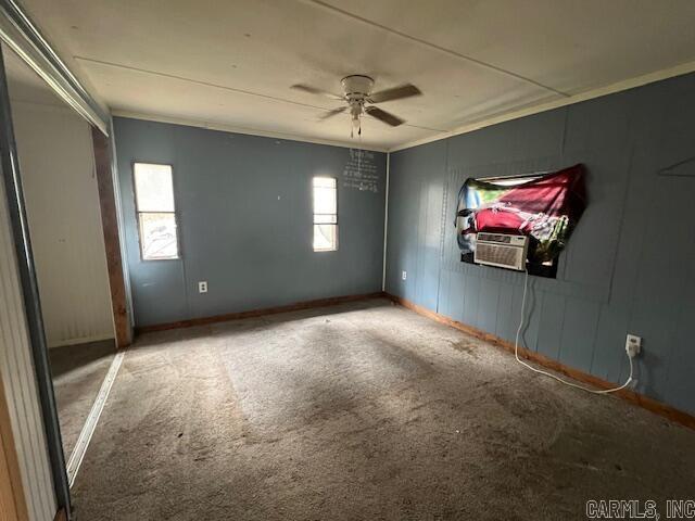 carpeted empty room featuring ceiling fan and crown molding