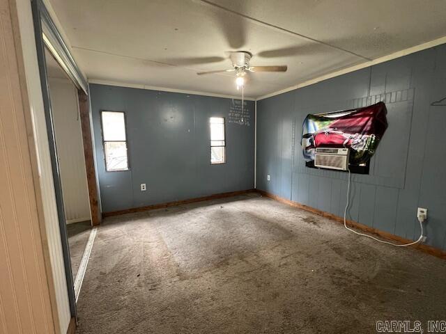 spare room with carpet flooring, ceiling fan, cooling unit, and crown molding