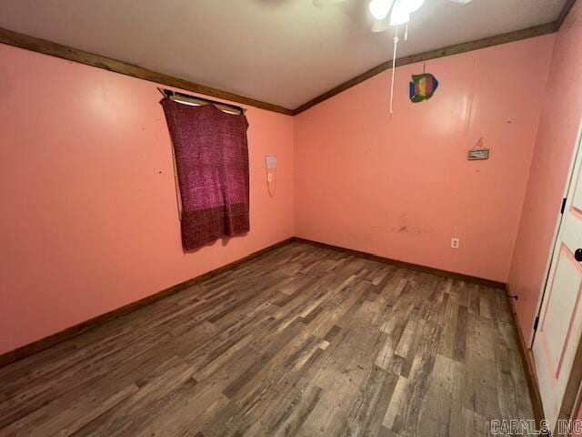 spare room featuring hardwood / wood-style floors, lofted ceiling, and crown molding