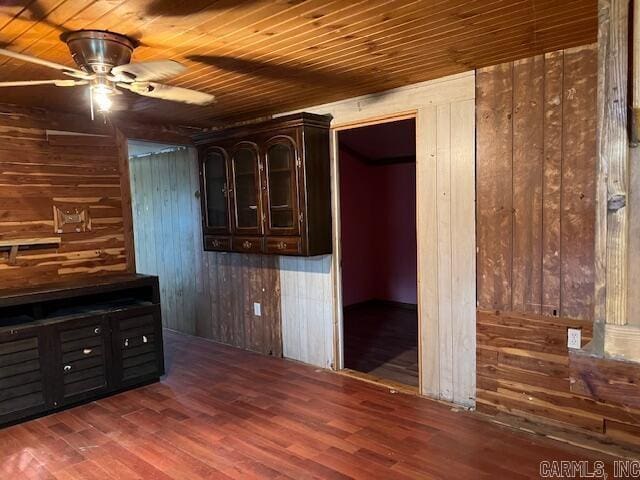 interior space with dark brown cabinetry, wooden walls, wooden ceiling, and dark hardwood / wood-style floors