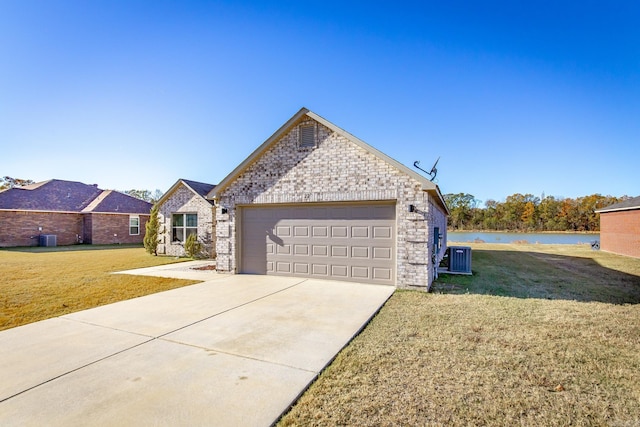 view of front of house with central AC unit, a water view, and a front lawn