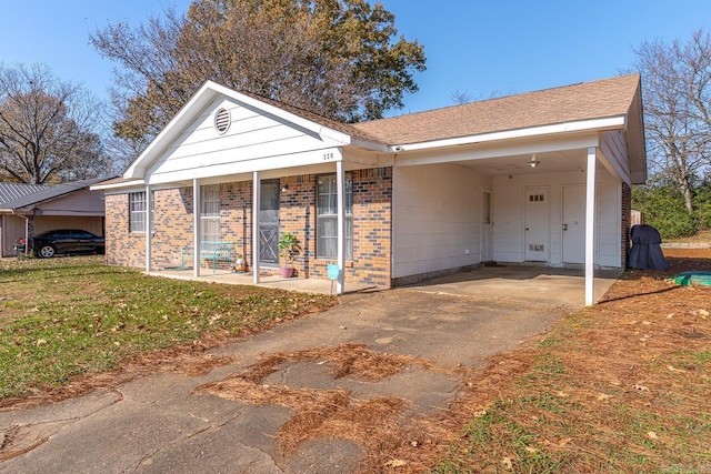 view of front of home with a carport, a porch, and a front lawn