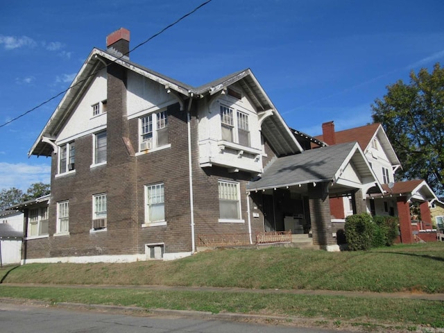 view of home's exterior with brick siding, a yard, and a chimney