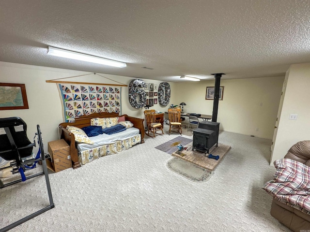 bedroom featuring carpet, a wood stove, and a textured ceiling