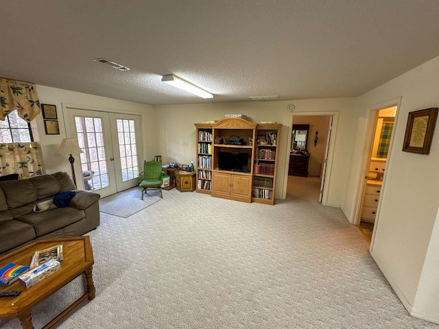 living room featuring carpet flooring, french doors, and a textured ceiling