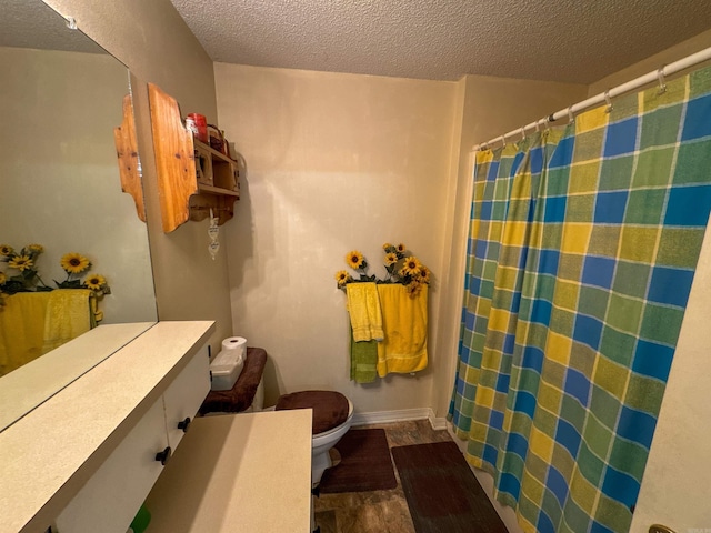 bathroom featuring toilet, a shower with shower curtain, a textured ceiling, and hardwood / wood-style flooring