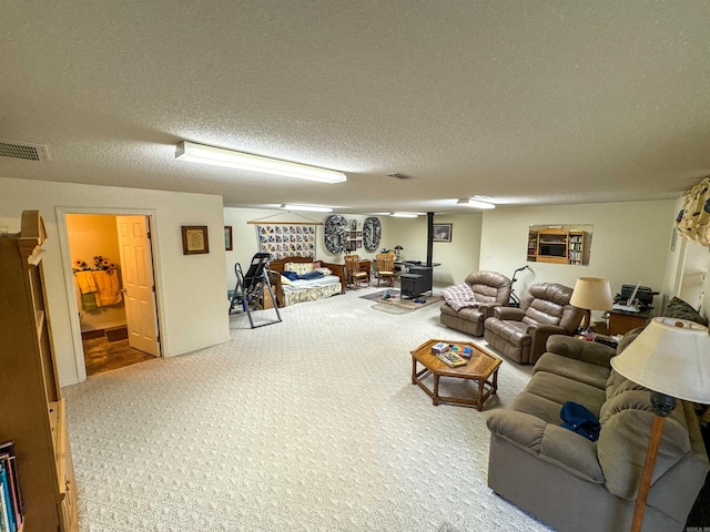 living room with carpet floors, a textured ceiling, and a wood stove