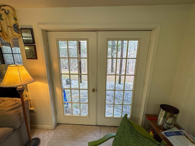 doorway featuring light carpet, french doors, and plenty of natural light