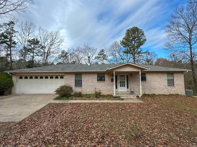 ranch-style house with a garage and central air condition unit