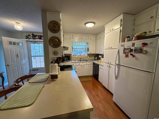 kitchen featuring dark hardwood / wood-style flooring, white fridge, white cabinetry, and plenty of natural light