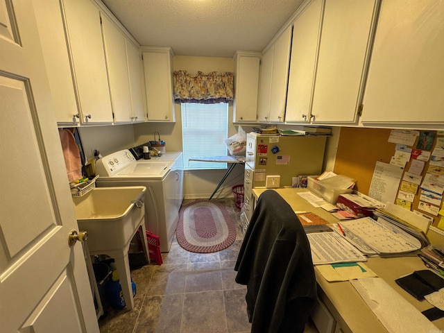 clothes washing area with dark tile patterned flooring, cabinets, a textured ceiling, and washing machine and clothes dryer