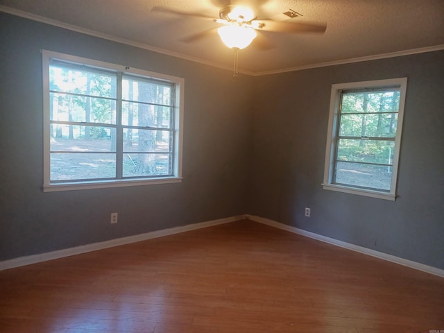 spare room featuring ceiling fan, crown molding, a healthy amount of sunlight, and hardwood / wood-style flooring