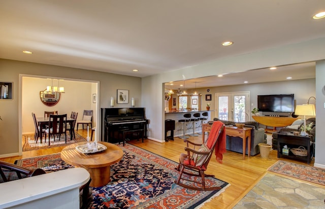 living room featuring hardwood / wood-style floors, a notable chandelier, and french doors