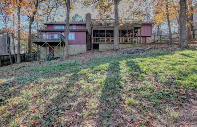 rear view of house featuring a yard and a wooden deck