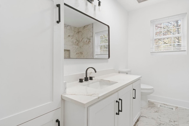 bathroom featuring vanity, toilet, and a healthy amount of sunlight