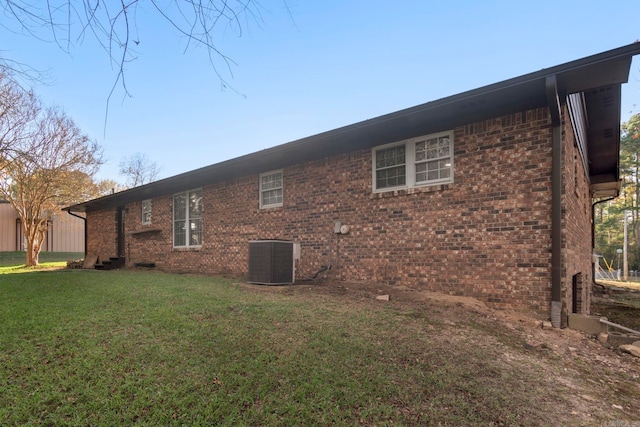 view of home's exterior with central air condition unit and a lawn