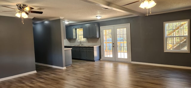 kitchen featuring french doors, a textured ceiling, crown molding, dark wood-type flooring, and sink