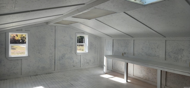 additional living space featuring light hardwood / wood-style flooring and lofted ceiling