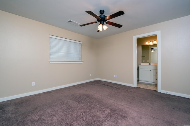 unfurnished bedroom featuring carpet, ensuite bath, and ceiling fan