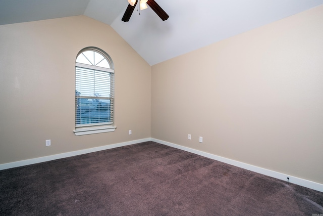 empty room with ceiling fan, dark carpet, and vaulted ceiling