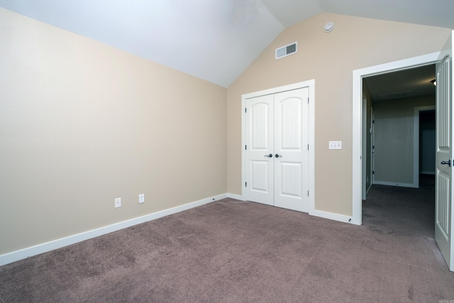 unfurnished bedroom featuring lofted ceiling, carpet floors, and a closet