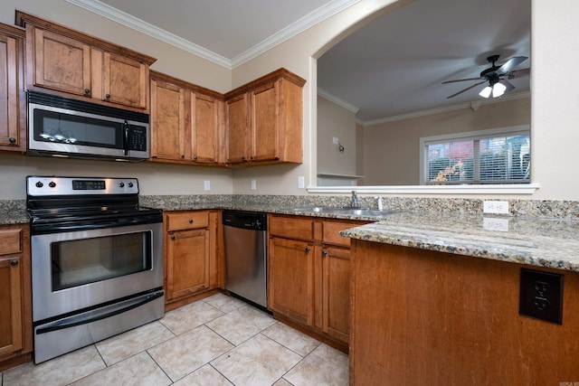 kitchen featuring ceiling fan, light tile patterned floors, ornamental molding, appliances with stainless steel finishes, and light stone counters