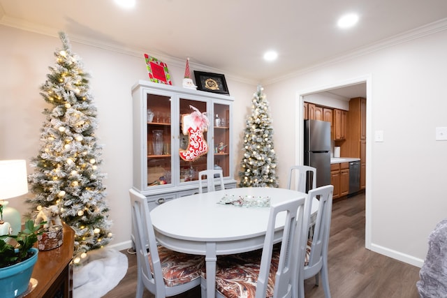 dining room with dark hardwood / wood-style floors and crown molding