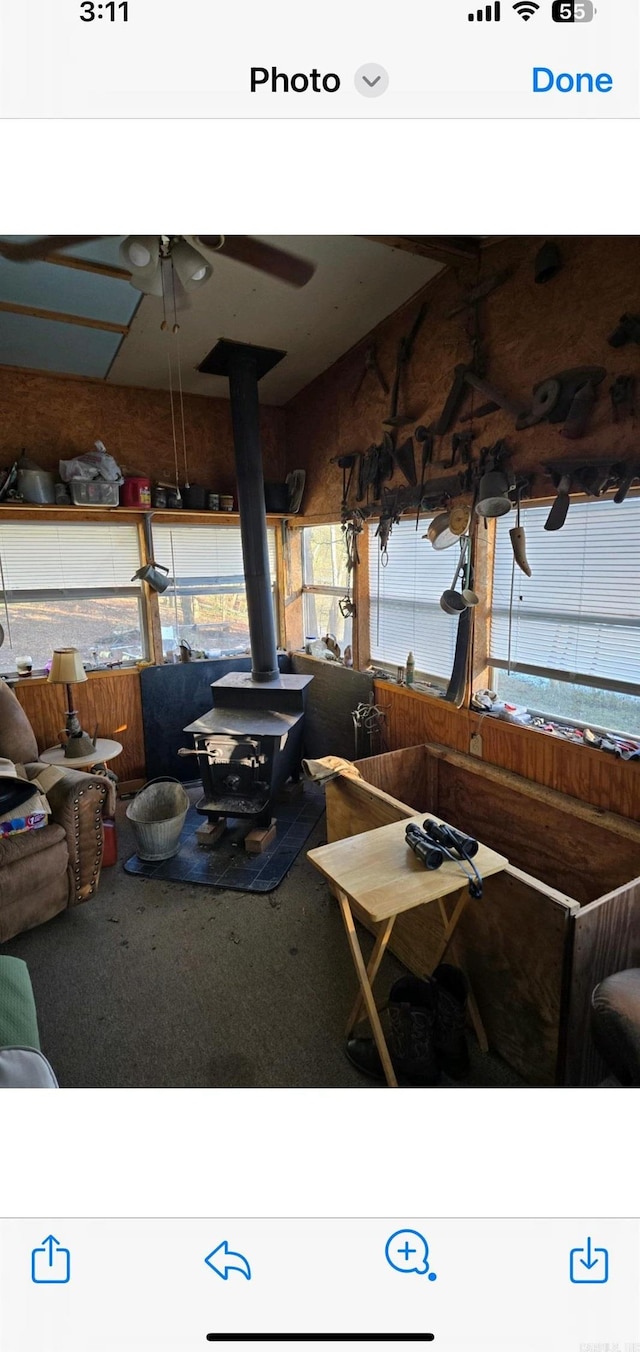 living room featuring carpet flooring and a wood stove