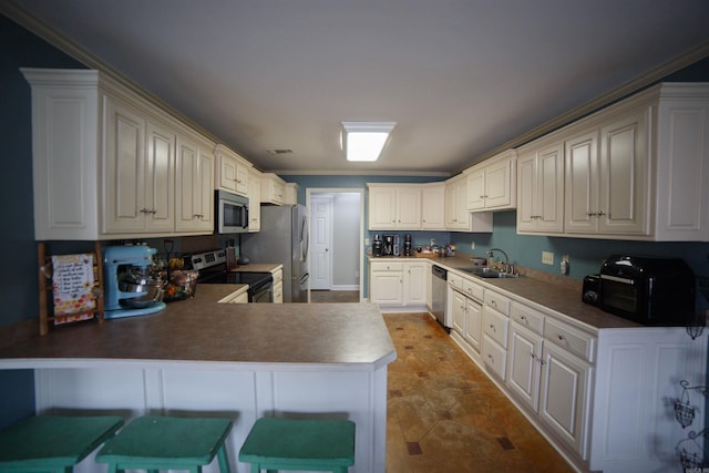 kitchen featuring a breakfast bar, sink, crown molding, kitchen peninsula, and stainless steel appliances