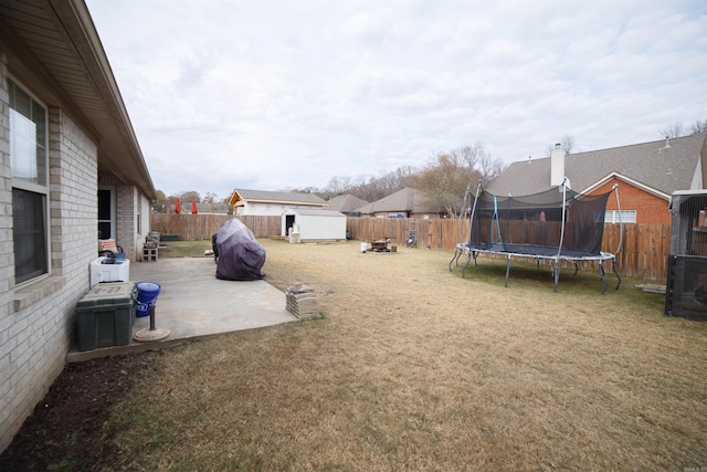 view of yard featuring a storage shed, a trampoline, and a patio