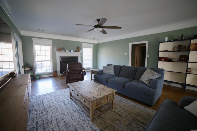 tiled living room with ceiling fan and ornamental molding