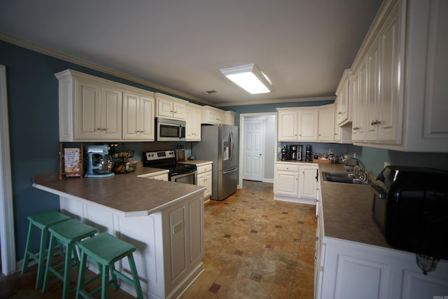 kitchen with white cabinetry, sink, kitchen peninsula, crown molding, and appliances with stainless steel finishes