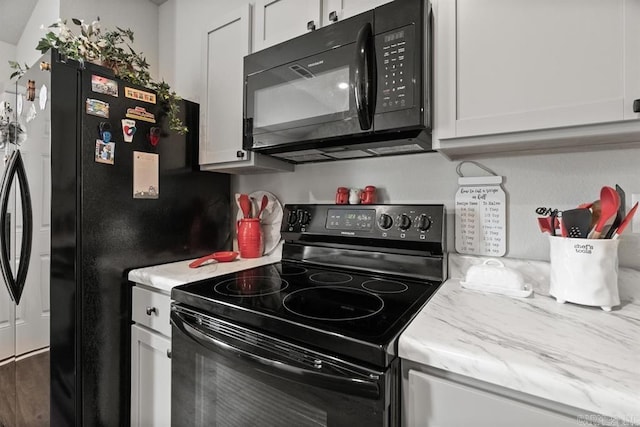 kitchen featuring black appliances and white cabinets