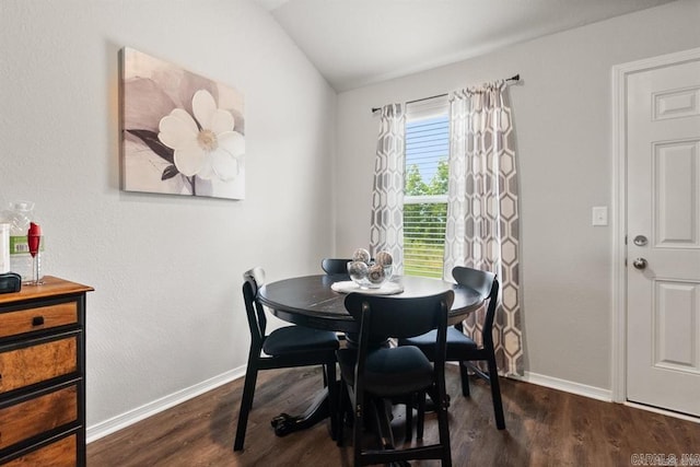 dining area with dark wood-type flooring and lofted ceiling