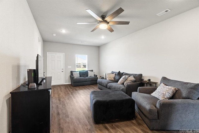 living room featuring ceiling fan and dark wood-type flooring