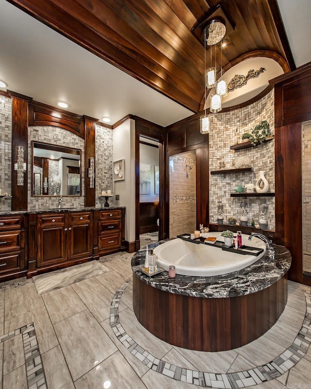 bathroom with lofted ceiling, vanity, and a tub