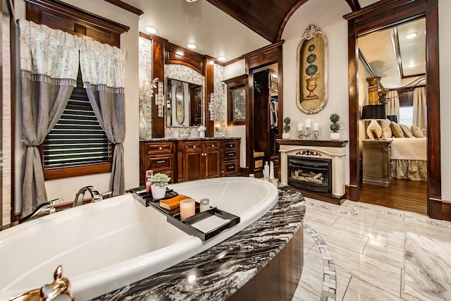 bathroom featuring vanity and tiled tub