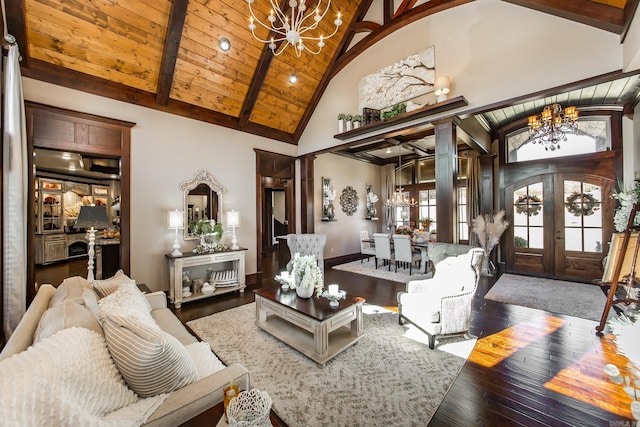 living room featuring high vaulted ceiling, an inviting chandelier, french doors, dark hardwood / wood-style floors, and ornate columns