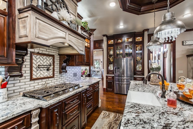 kitchen featuring hanging light fixtures, sink, ornamental molding, appliances with stainless steel finishes, and tasteful backsplash