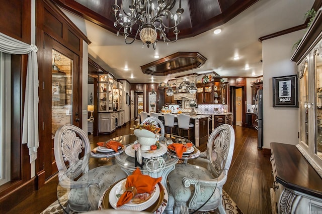 dining area with dark hardwood / wood-style flooring, ornamental molding, and a notable chandelier