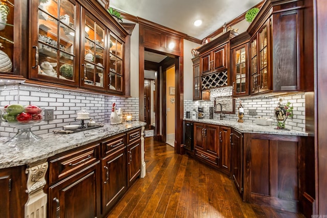 bar with backsplash, crown molding, sink, dark hardwood / wood-style floors, and light stone countertops