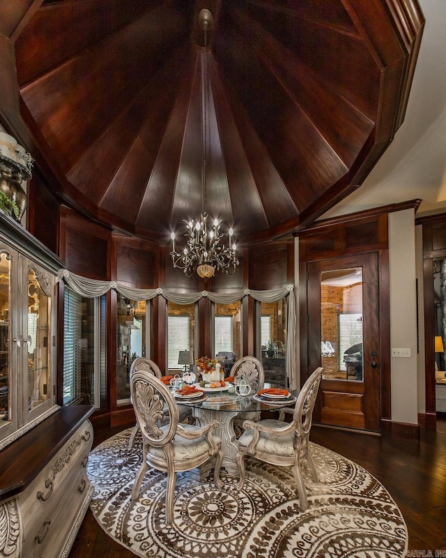 dining space featuring dark hardwood / wood-style floors, lofted ceiling, wooden walls, and an inviting chandelier